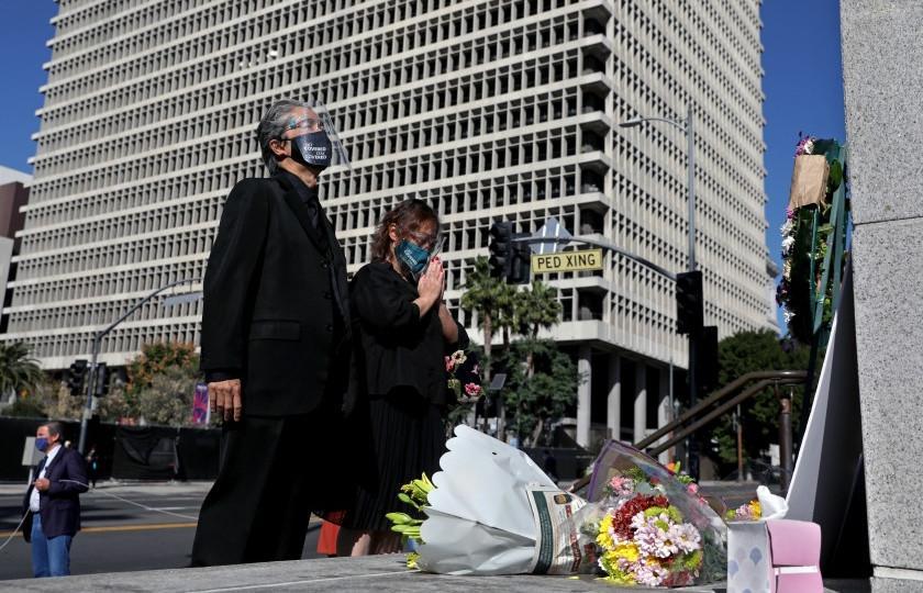 In this undated photo, court interpreter Nao Ikeuchi, left, and wife Yoshimi Shirata attend a vigil to honor two court interpreters at Los Angeles Superior Court who died recently of COVID-19.(Gary Coronado / Los Angeles Times)